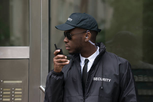Portrait Of Young African Male Security Guard Talking On Walkie-Talkie